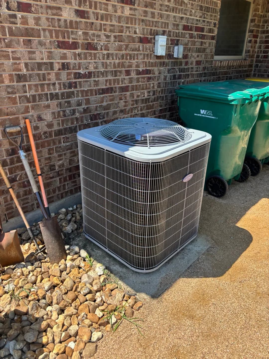 New Carrier outdoor air-conditioning system installed beside a brick home
